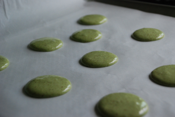 Piping matcha green tea macarons