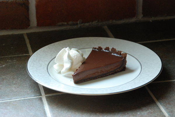 Slice of chocolate tart with chocolate graham cracker crust