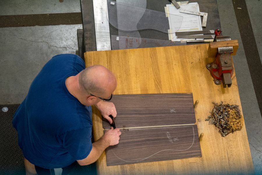 Scraping the glue from guitar bodies at Martin Guitar factory.