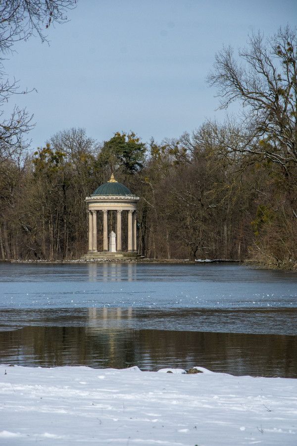 Looking across the frozen lake at Monopteros in Nymphenburg Park, Munich, Germany.