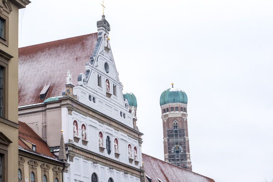 The St Michael Kirche and the towers of the Frauenkirche in snow in Munich, Germany.