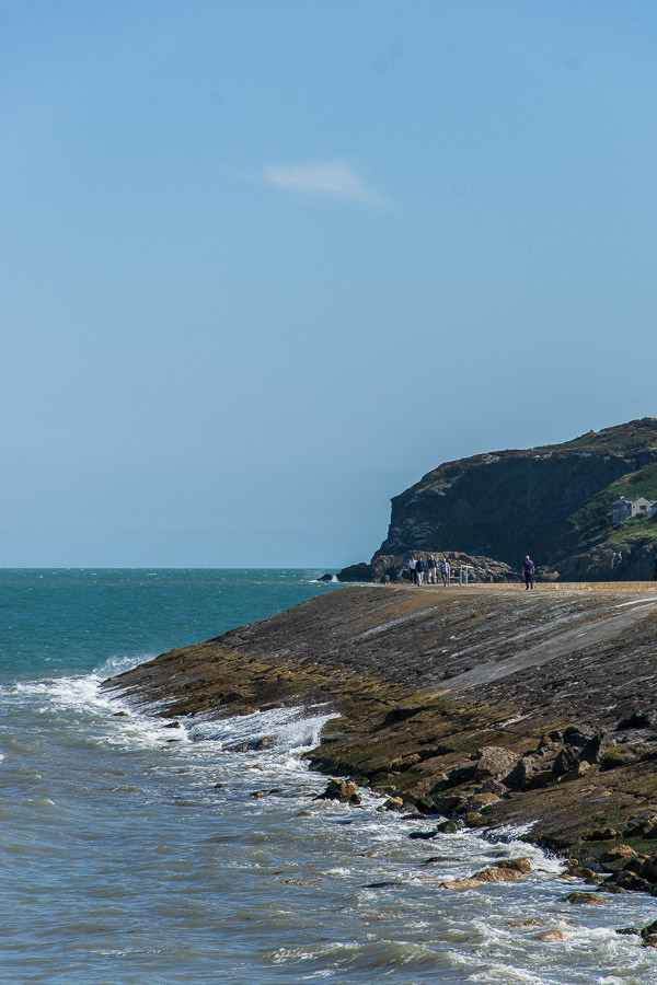 The bay rushes up on the edge of the Howth Pier .