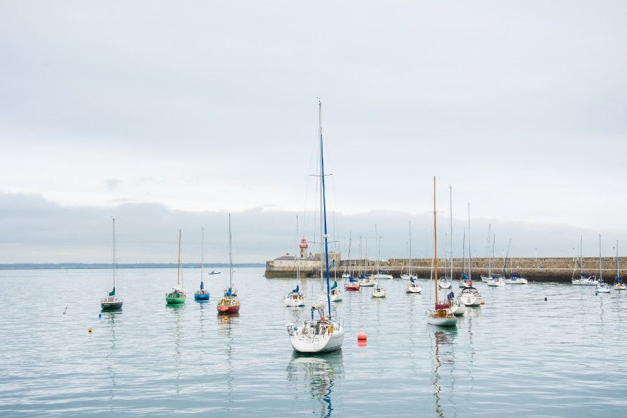 Sailboats in the Dún Laoghaire harbor in front of the lighthouse.