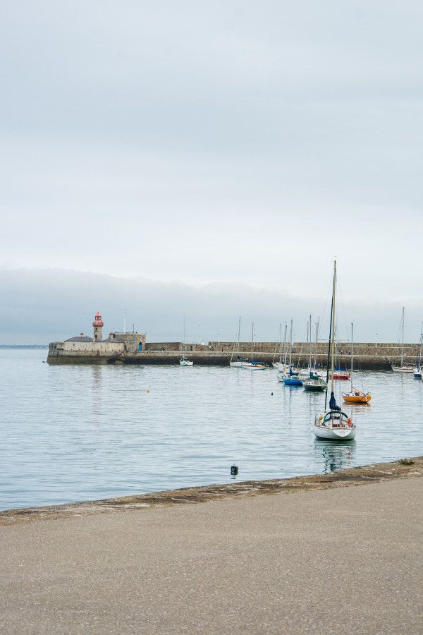 Lighthouses and sailboats in the harbor in Dún Laoghaire, Ireland.