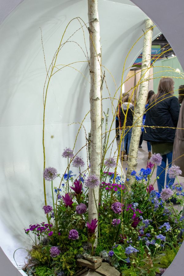 Colorful flowers poke out of an oval nook.