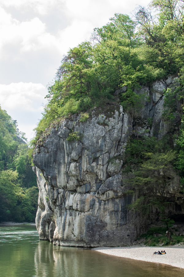 Sunbathers lie on the stone beach near the white stone along the Danube River Gorge, or Donaudurchbruch.