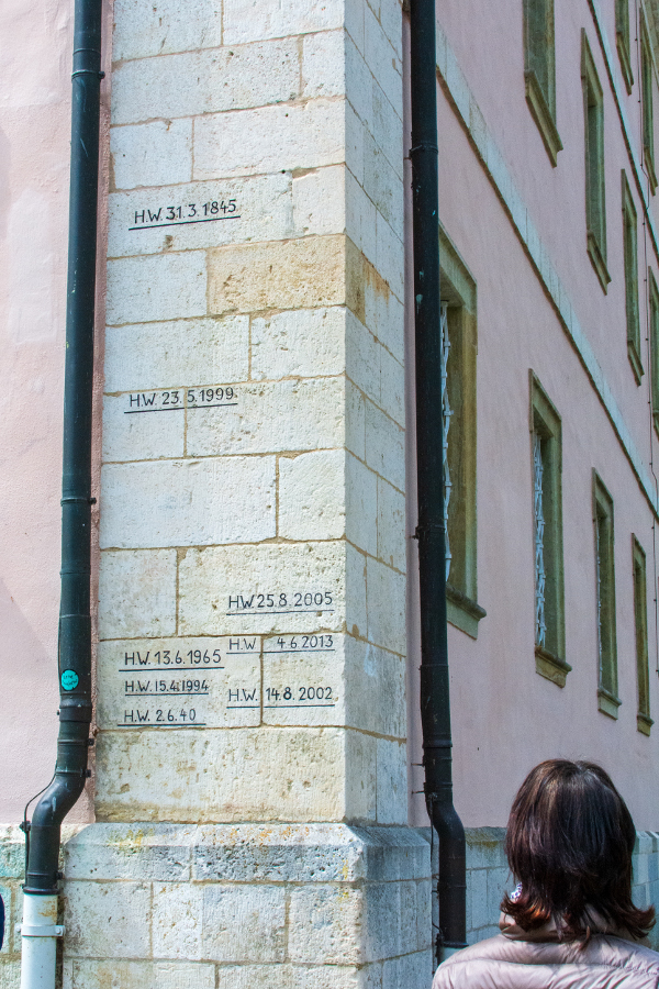 Lines on a wall show high water parks for different dates at Kloster Weltenburg.