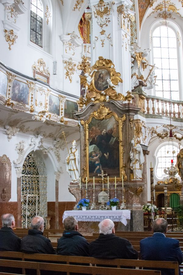 Men sit in prayer in Kloster Andech's church.