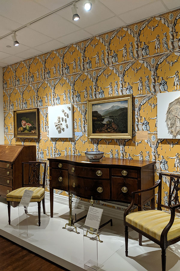 Antique furniture and paintings inside the Biggs Museum of American Art.