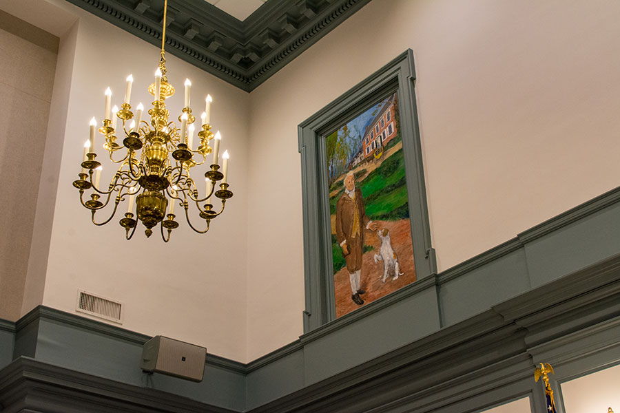 A painting and chandelier sit above a chamber of the Delaware Legislative Hall.