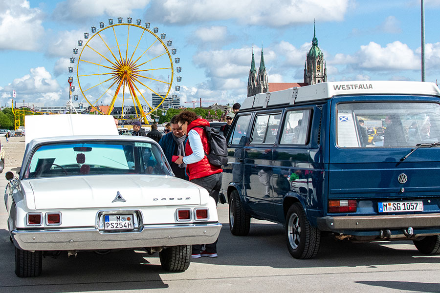 A Dodge and a VW Westfalia on show at the ACM Oldtimer-Treffen with the Munich Frühlingsfest Ferris wheel in the background.