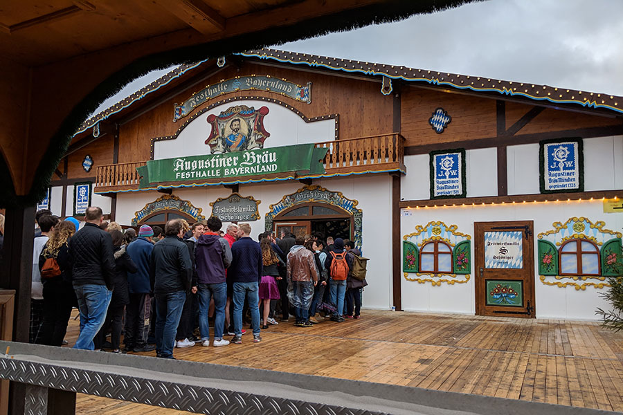 A line of people queue up in front of the Festhalle Bayernland for Frühlingsfest.