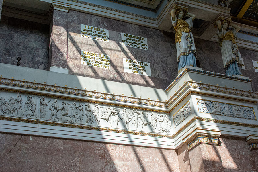 Sunlight plays along the wall of Walhalla Memorial across plaques.