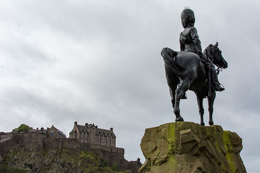 The Royal Scots Greys monument stands proudly before Edinburgh Castle in the distance.