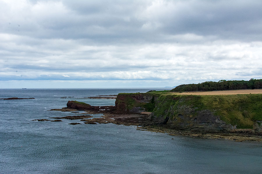 A cliff juts out into the bay in East Lothian, Scotland.