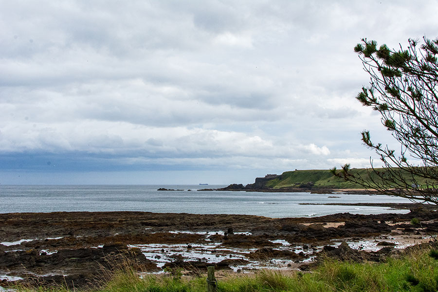 A view from the beaches of North Berwick towards Tantallon Castle sitting on the cliff edge.