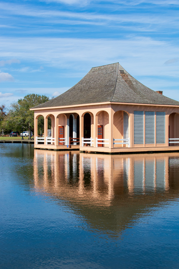 A coral-colored boathouse sits on the edge of the waterfront.