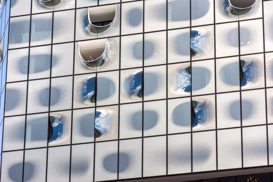 A guest leans out a window of the Elbphilharmonie.