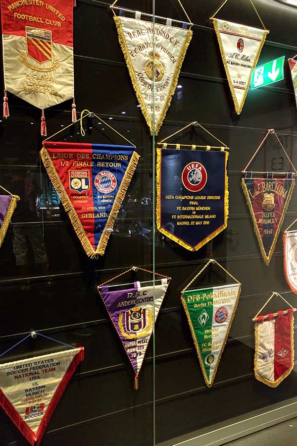 Flags line a wall inside the FC Bayern Erlebniswelt Museum.