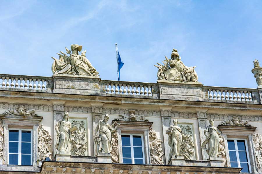 Elaborate stone sculptures line the top of the Herrenchiemsee New Palace.