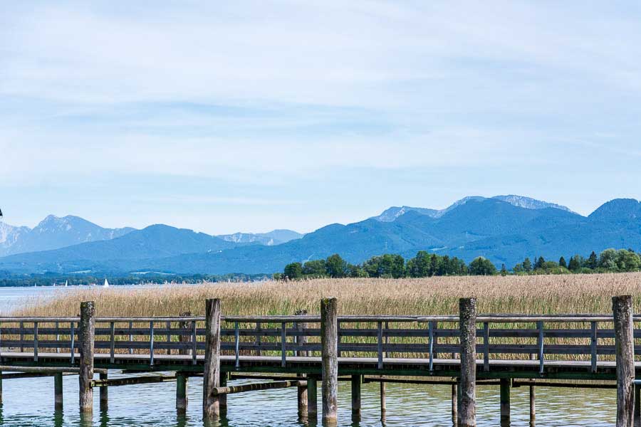 The Chiemgau Alps visible in the distance of the dock along the Chiemsee lake.