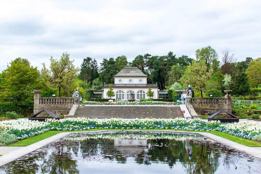 The Schmuckhof sits before a reflecting pool at the Munich Botanical Garden.