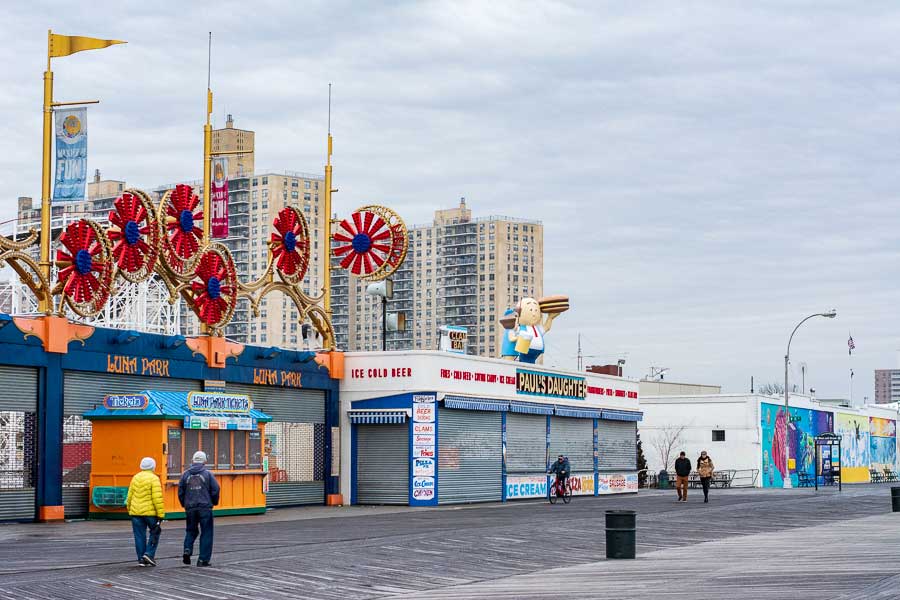 Visitors walk the boardwalk during winter at Coney Island.