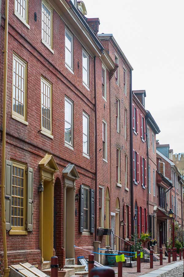 Historic brick buildings line the narrow cobblestone street.