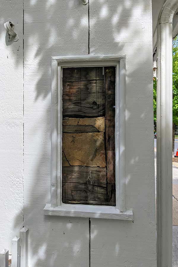 A window offers a peek at the historic wood building.