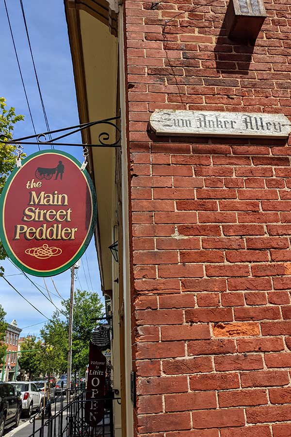 Signs for the Main Street Peddler and Zum Anker Alley line Main Street in Lititz, PA. Shopping will top the list of things to do in Lititz, PA.