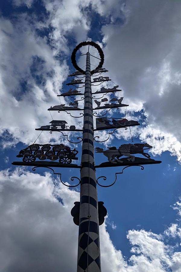 A Maibaum soars into the sky outside of the Hofbräuhaus Pittsburgh.