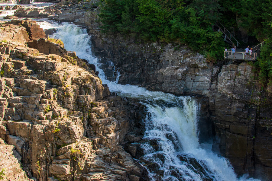 Visitors on a platform view the Canyon Sainte-Anne waterfall.