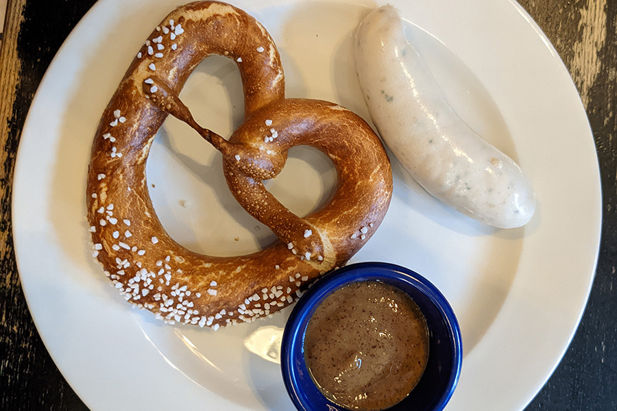 A Münchner Weißwurst sausage, a pretzel, and sweet mustard.