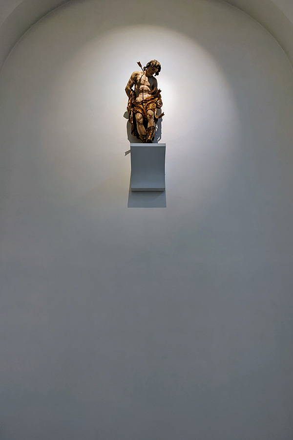 A religious statue sits on a shelf in the St. Moritz Church.