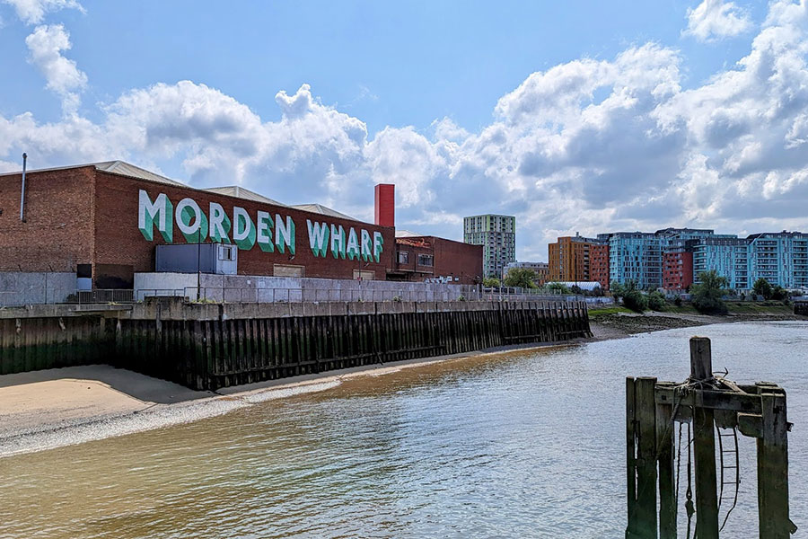 Buildings and the wharf along the Thames Path section in Greenwich.