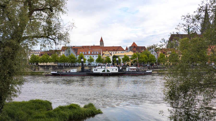 A ferry sits along the banks of the Danube River in Regensburg, Germany.