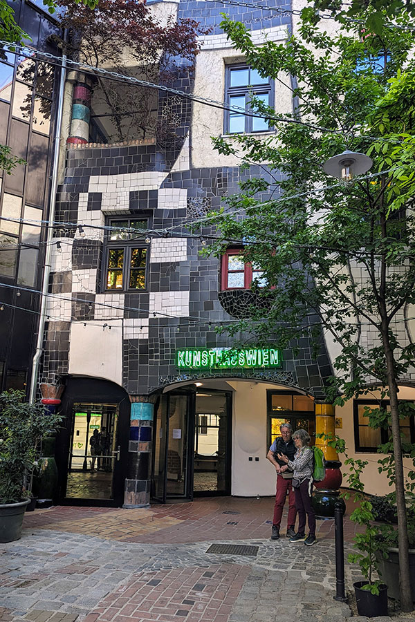 Exterior of KunstHausWien, featuring Hundertwasser's signature mosaic tiles and vibrant architecture.